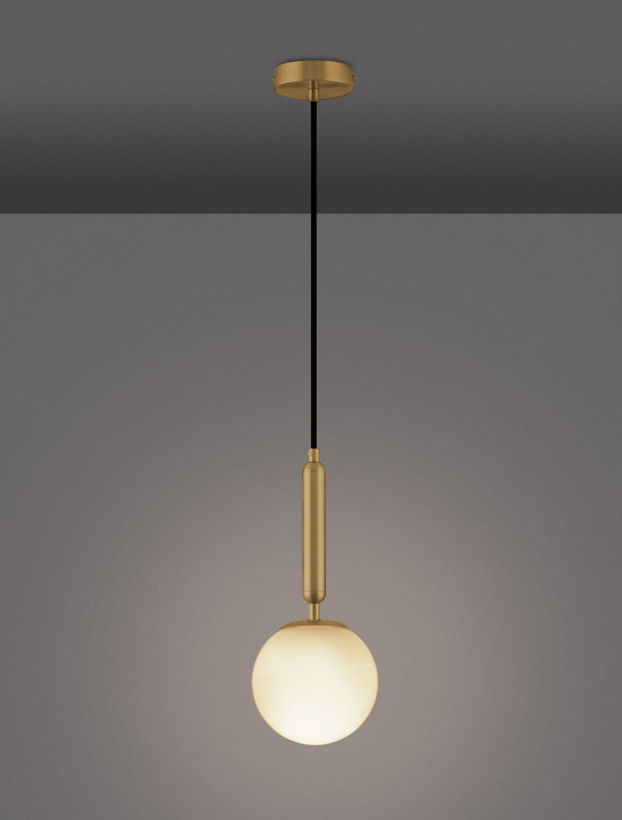 Le luminaire allumé sur fond gris foncé, diffusant une lumière chaude à travers le verre.