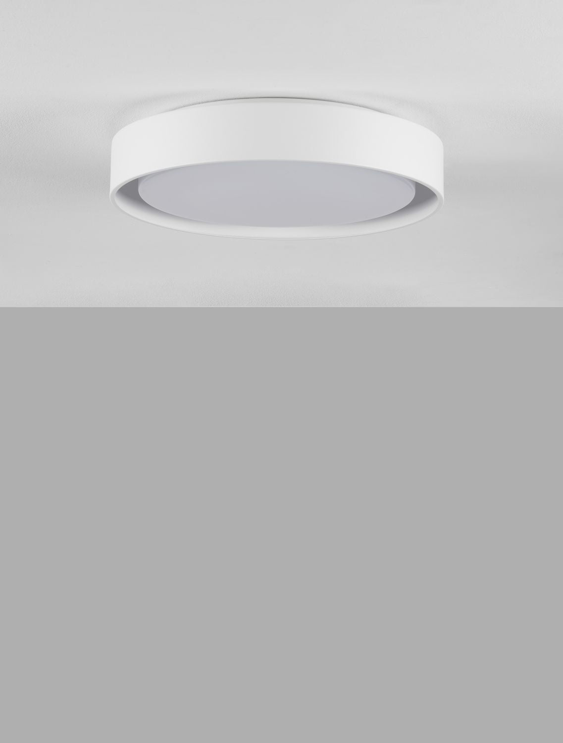 Plafonnier blanc circulaire monté au plafond, éclairage doux diffusé vers le bas.