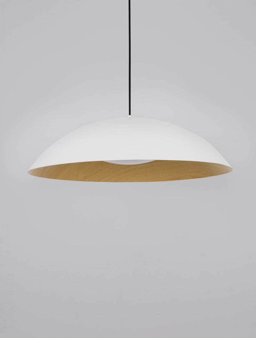 Vue rapprochée de la suspension blanche, abat-jour hémisphérique et finition intérieure en bois naturel.