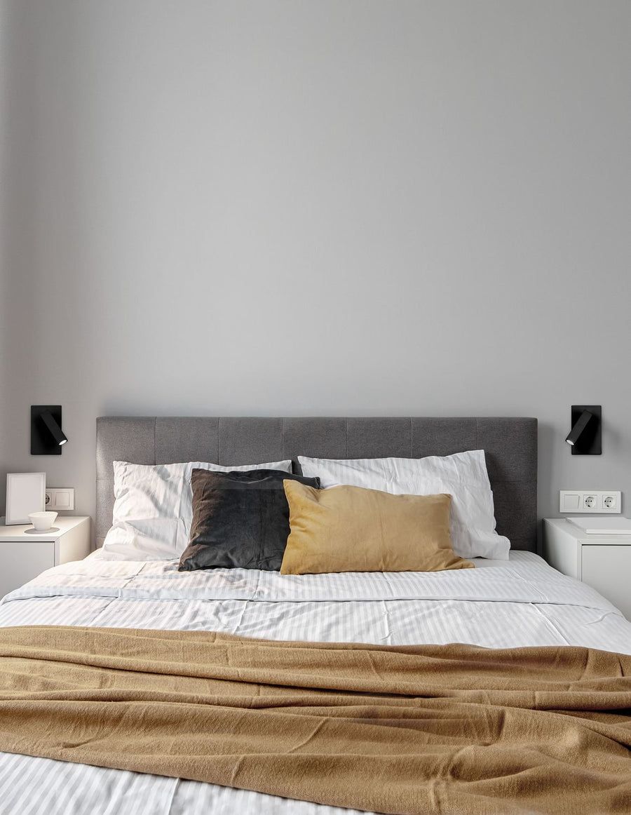 Applique murale noire installée de part et d'autre du lit dans une chambre moderne