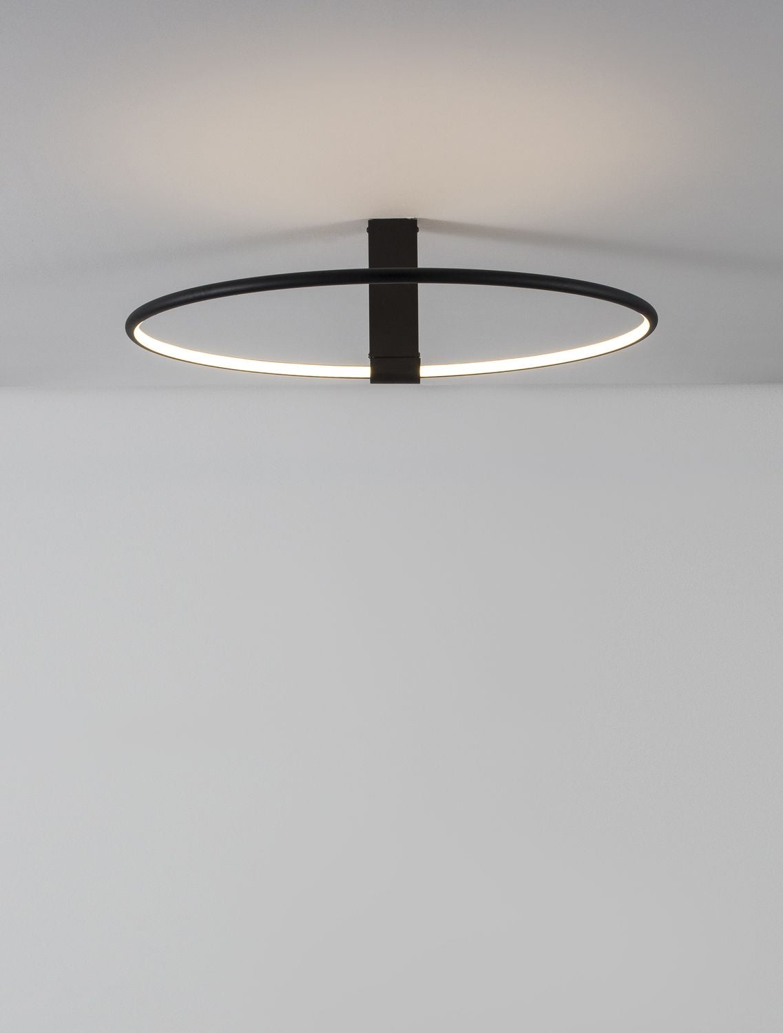 Suspension noire vue de dessous, anneau lumineux allumé près du plafond blanc