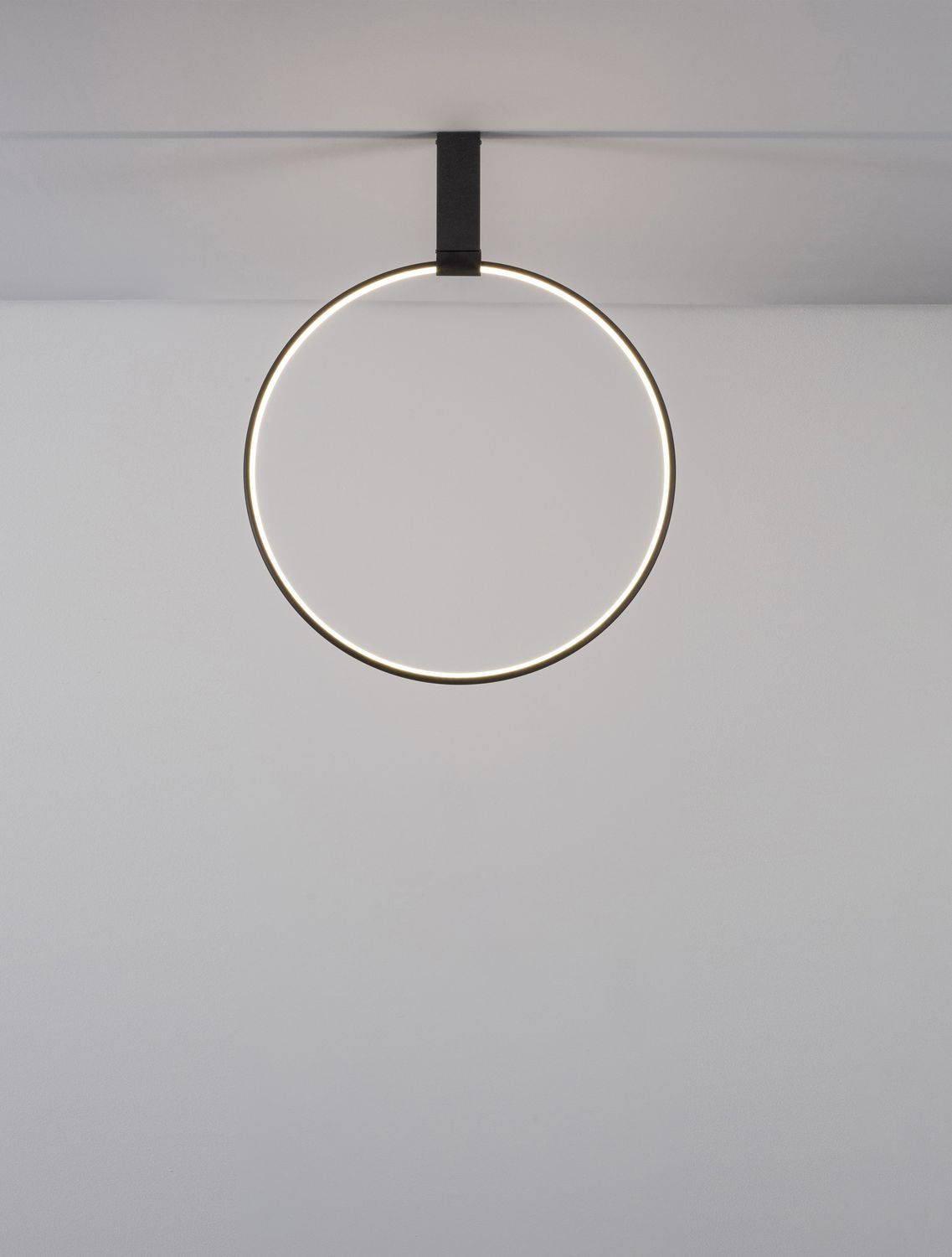 Vue frontale de l'anneau allumé, lumière chaude diffusée sur le mur