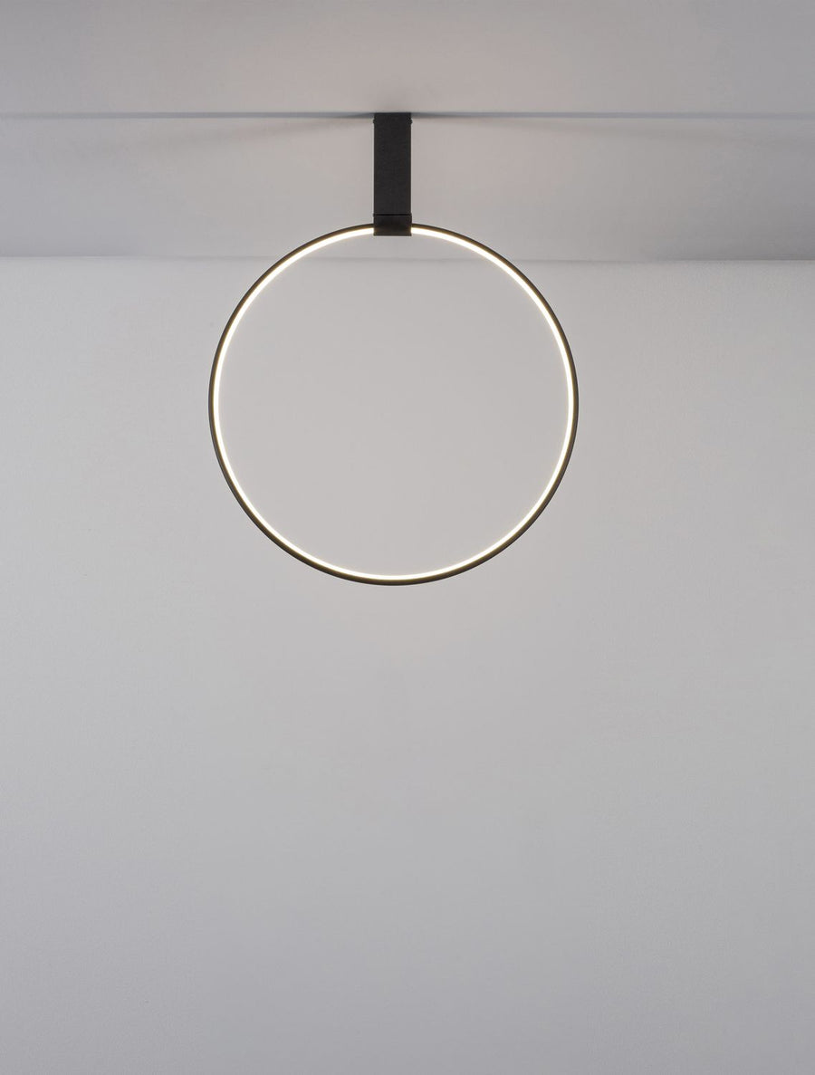 Vue frontale de l'anneau allumé, lumière chaude diffusée sur le mur