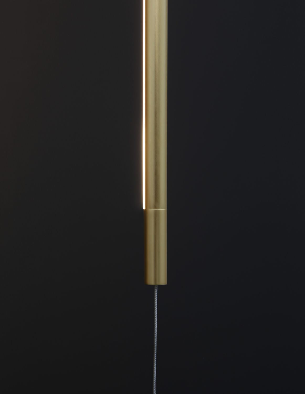 Détail du tube laiton avec fente lumineuse et finition brossée.