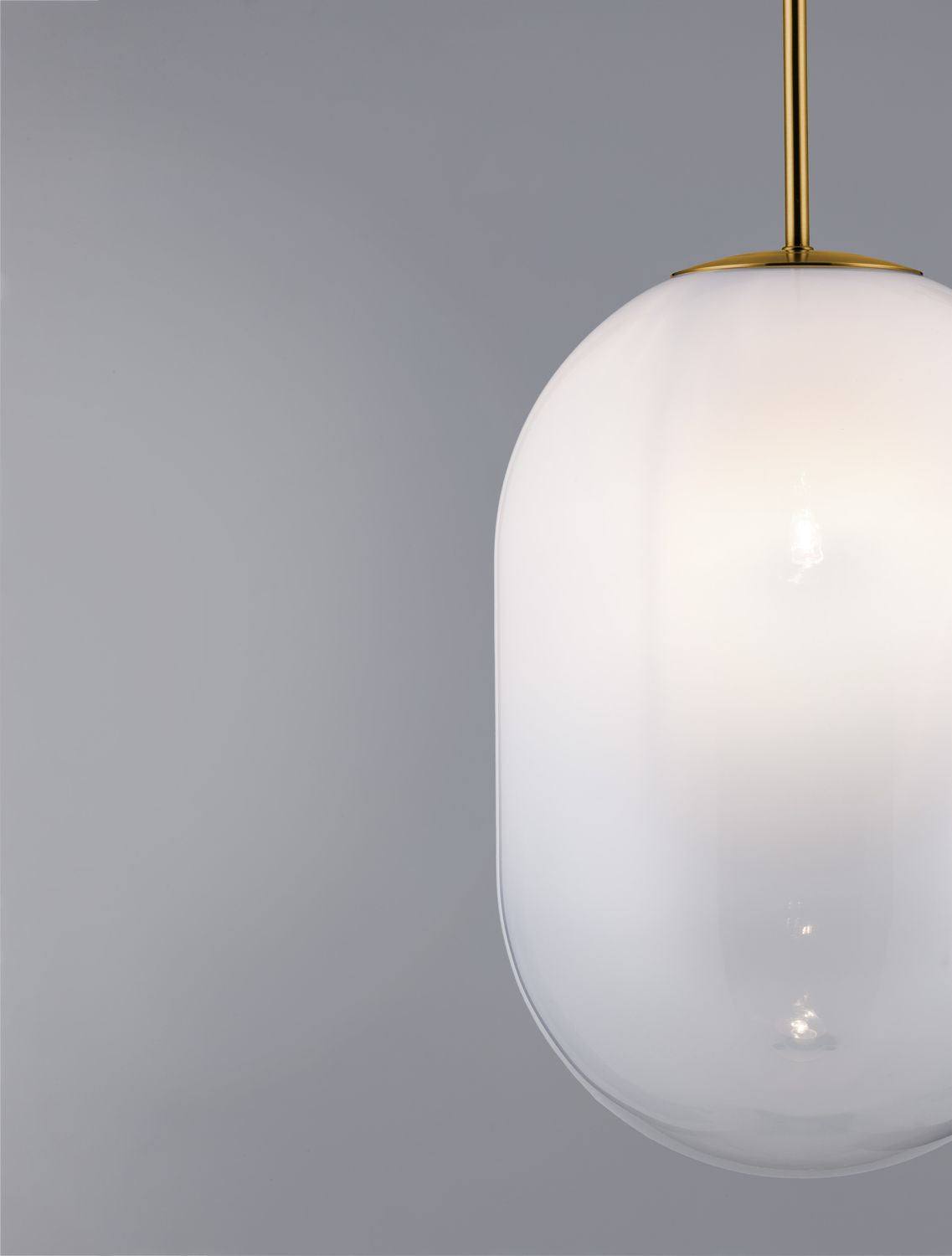 Gros plan de la partie supérieure dorée et du globe en verre sur fond gris.