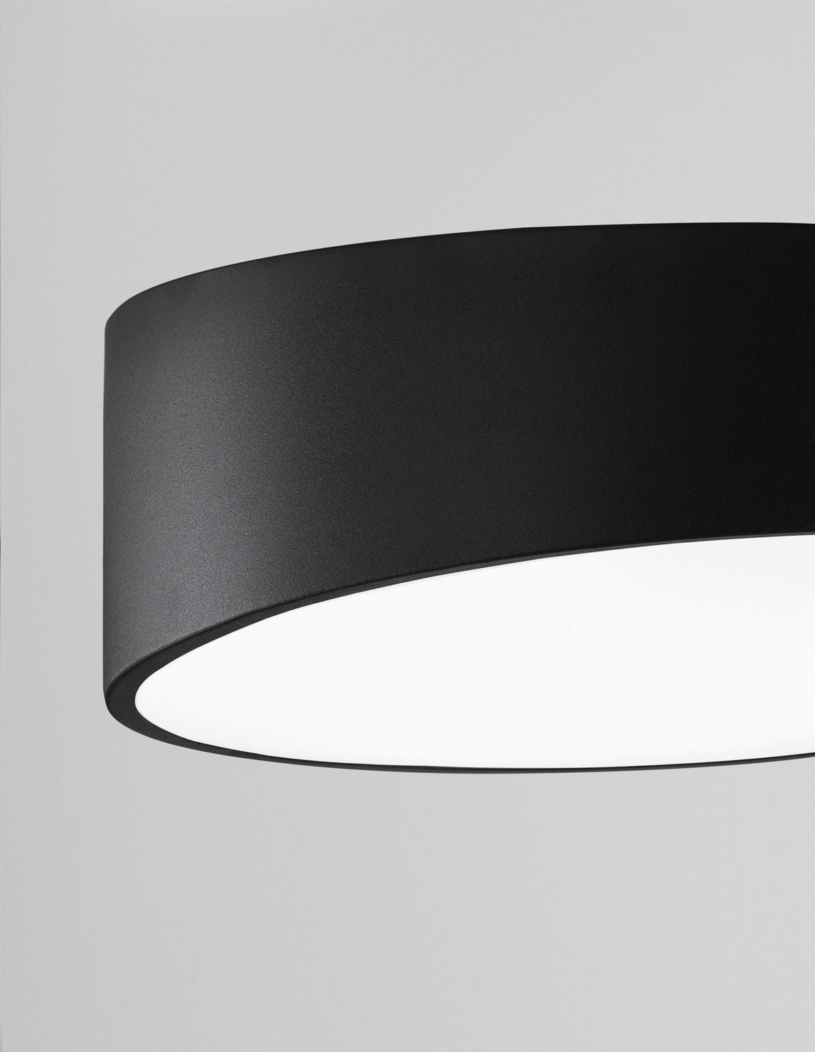 Détail rapproché du bord métallique noir et du diffuseur laiteux