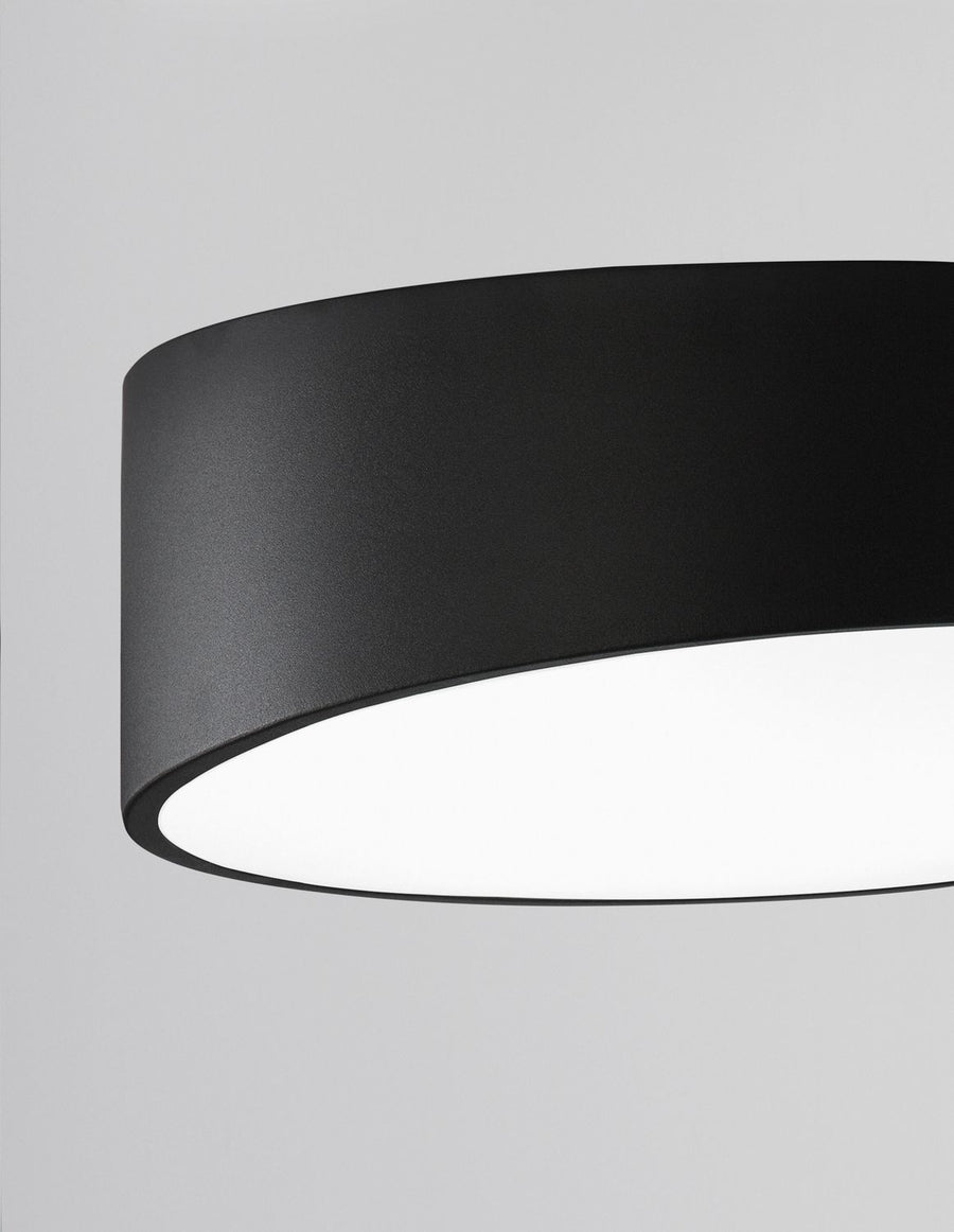 Détail rapproché du bord métallique noir et du diffuseur laiteux