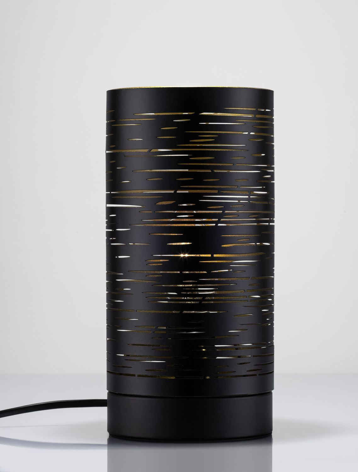 Lampe allumée de face, lumière dorée traversant les fentes horizontales