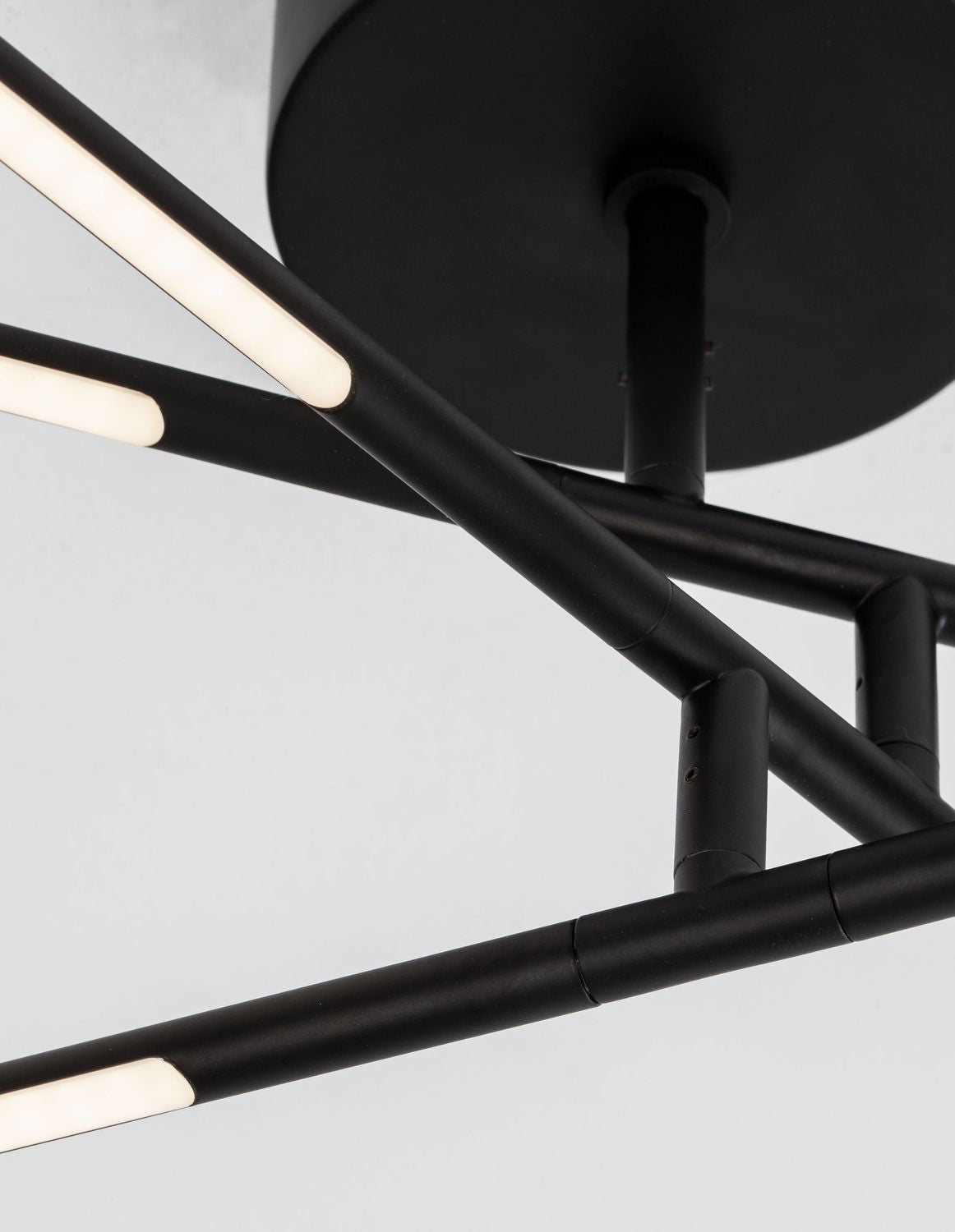 Détail rapproché des jonctions entre tubes et bandeaux LED allumés