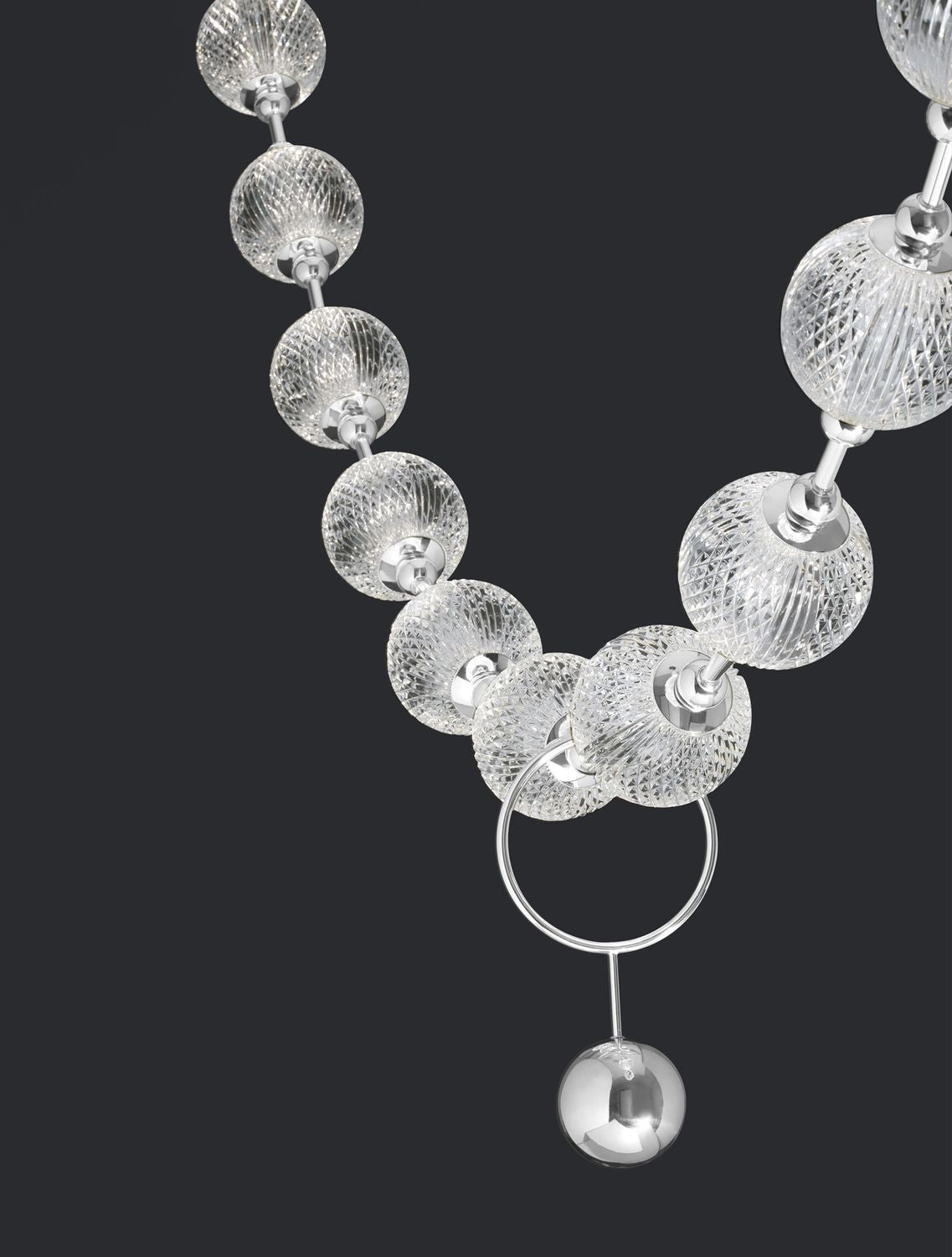 Détail rapproché des sphères de verre texturé et de l'anneau chromé