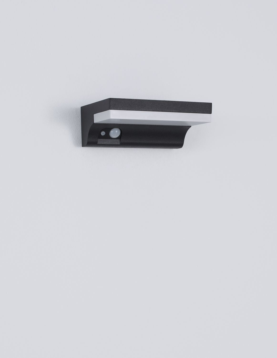 Produit de face sur fond gris, boîtier anthracite granuleux et bandeau lumineux blanc.