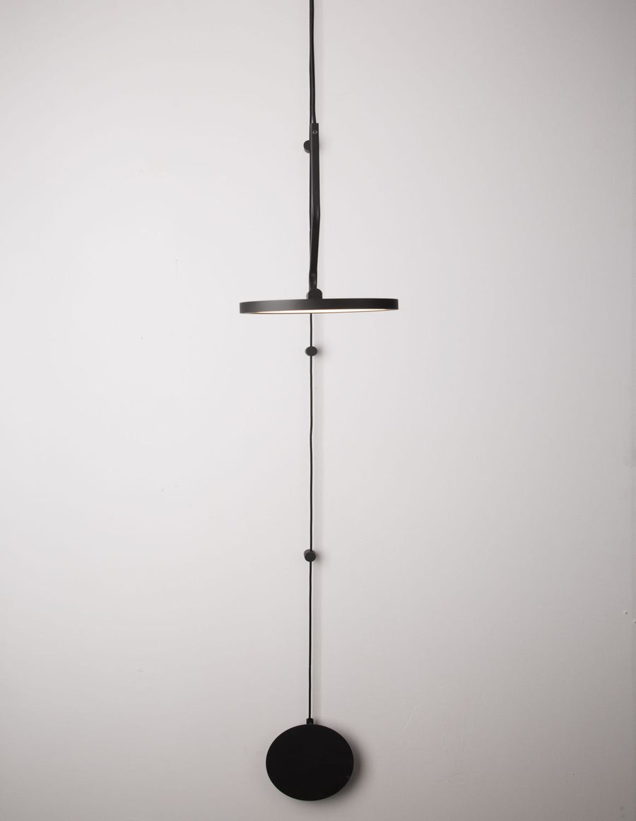 Produit entier suspendu, anneau plat noir et disque contrepoids en bas.