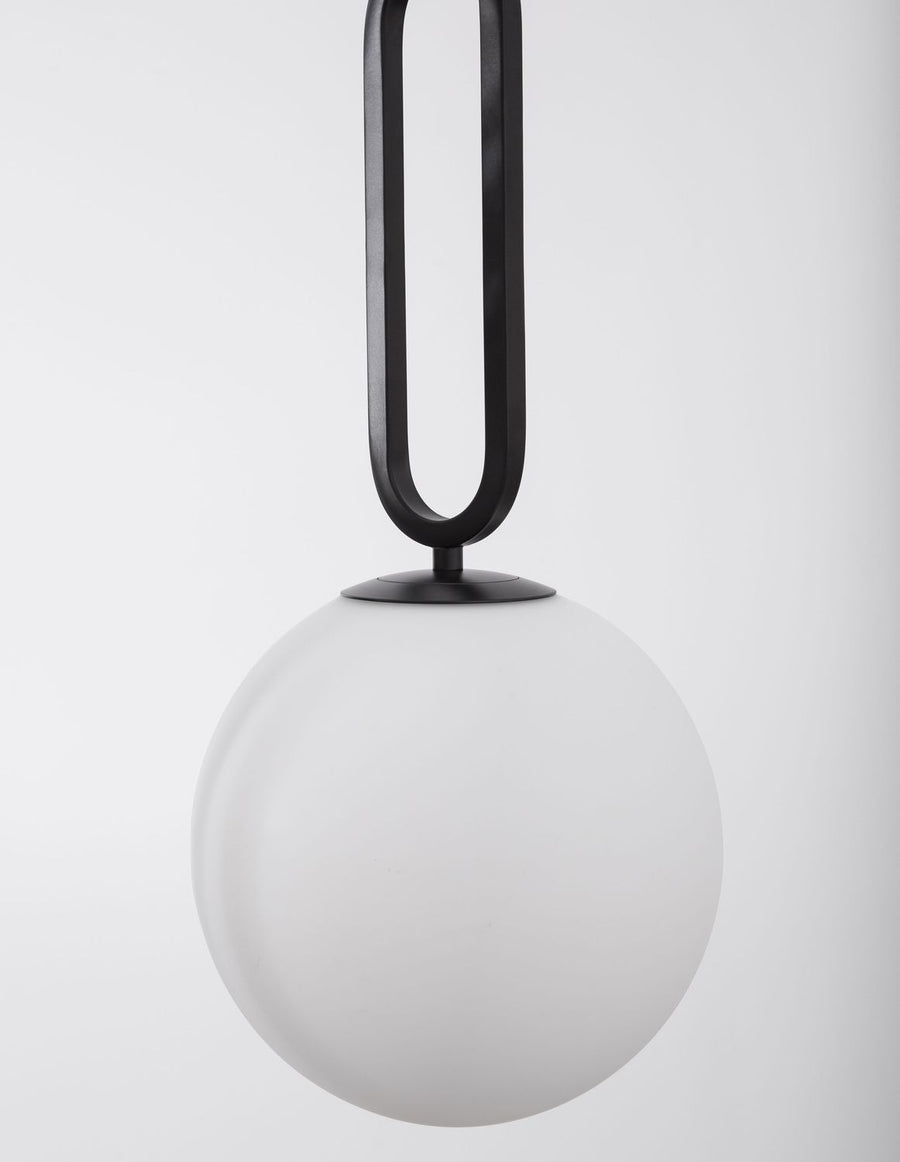 Gros plan sur l'attache noire et le globe de verre blanc dépoli