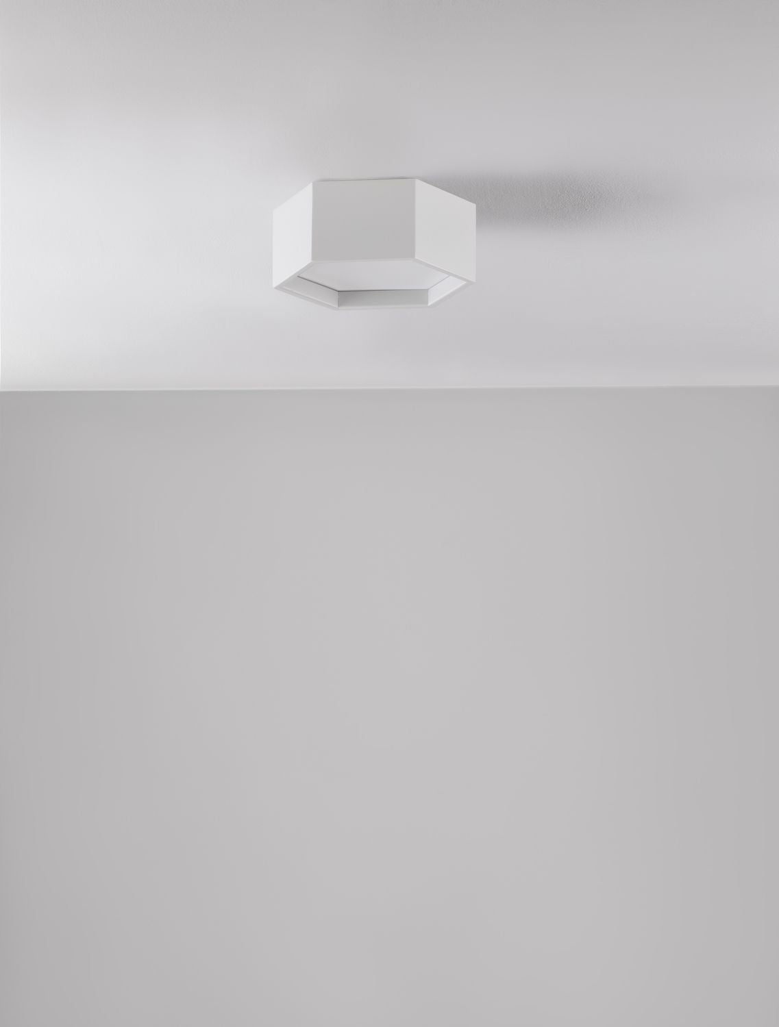 Plafonnier blanc fixé au plafond dans une pièce aux murs gris