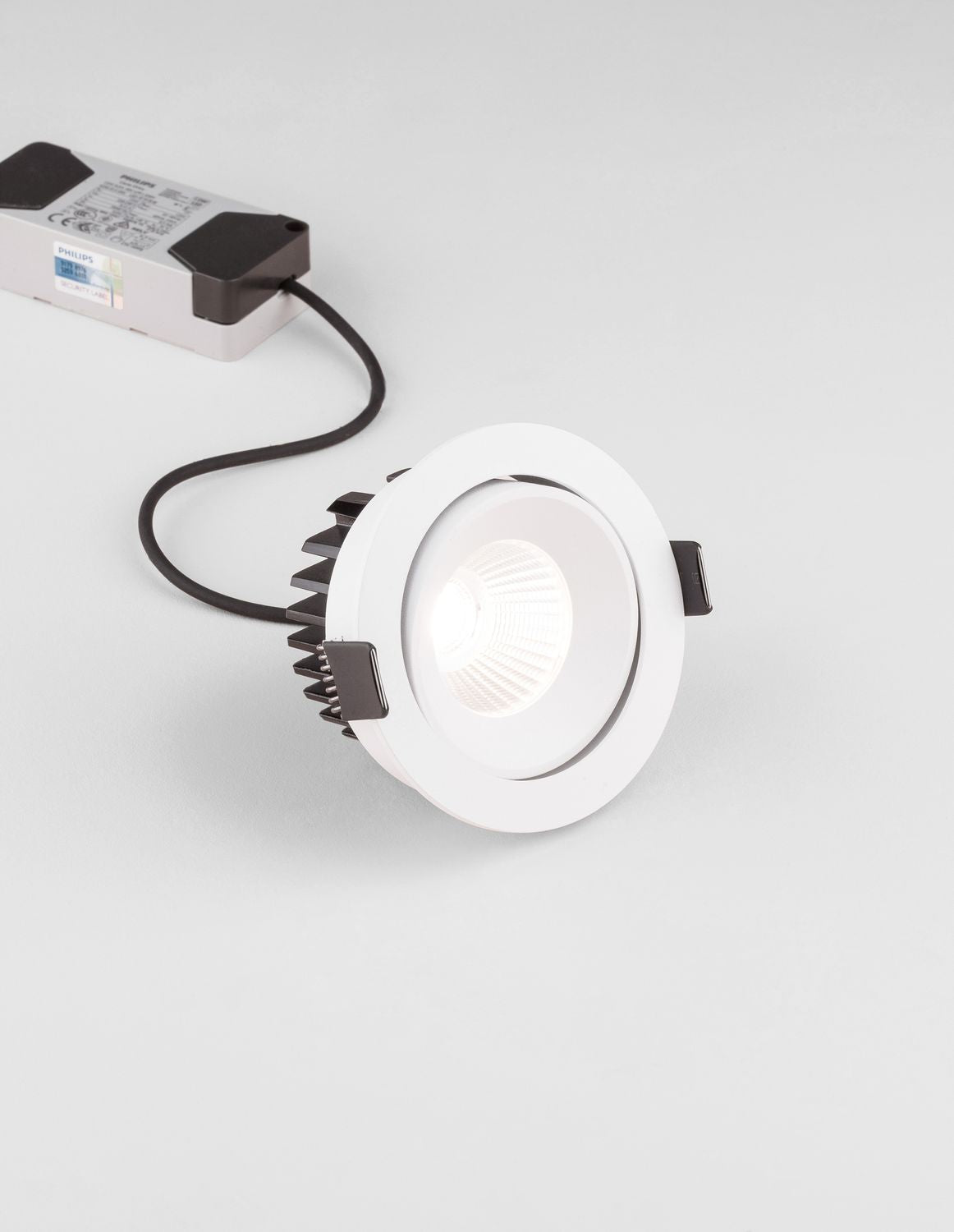 Projecteur encastrable blanc présenté avec son driver et son câble sur fond blanc.