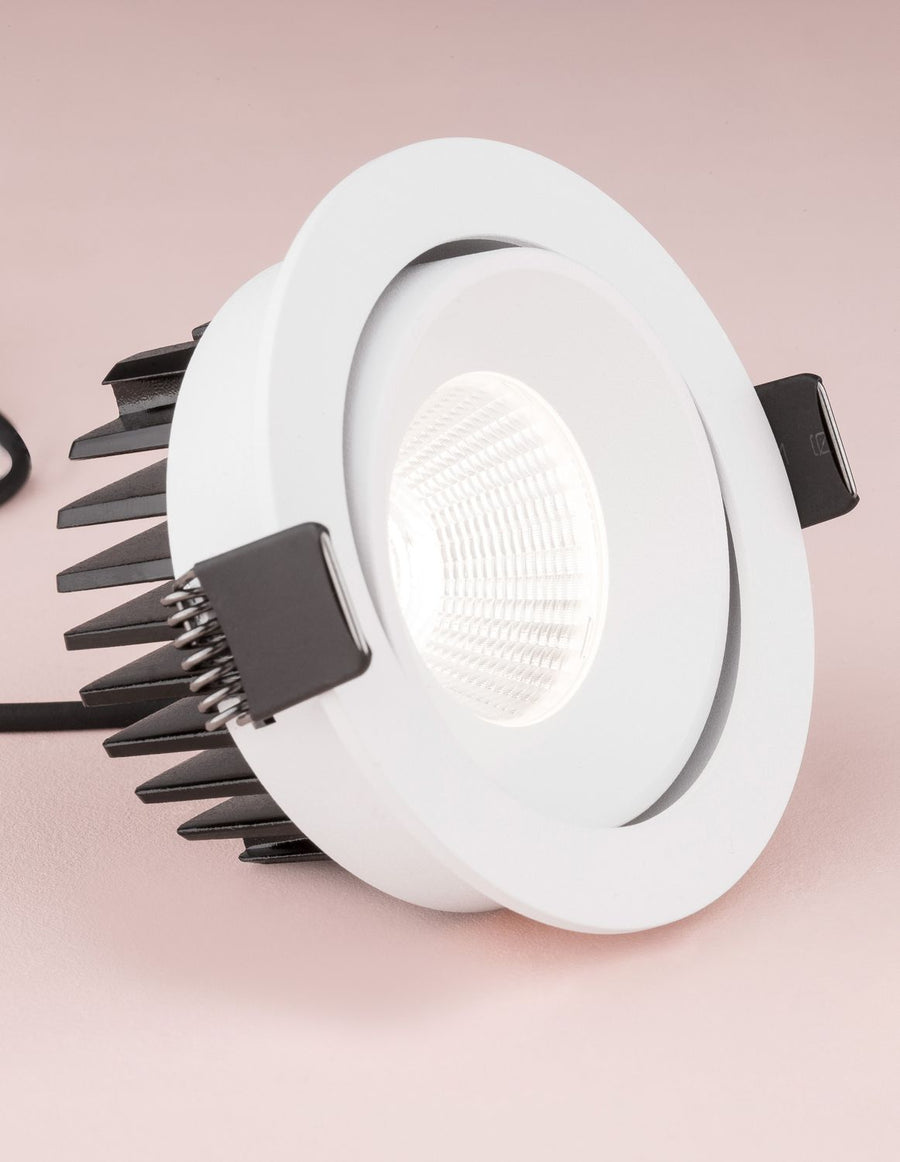Gros plan sur la lentille striée et la collerette blanche du projecteur encastrable.