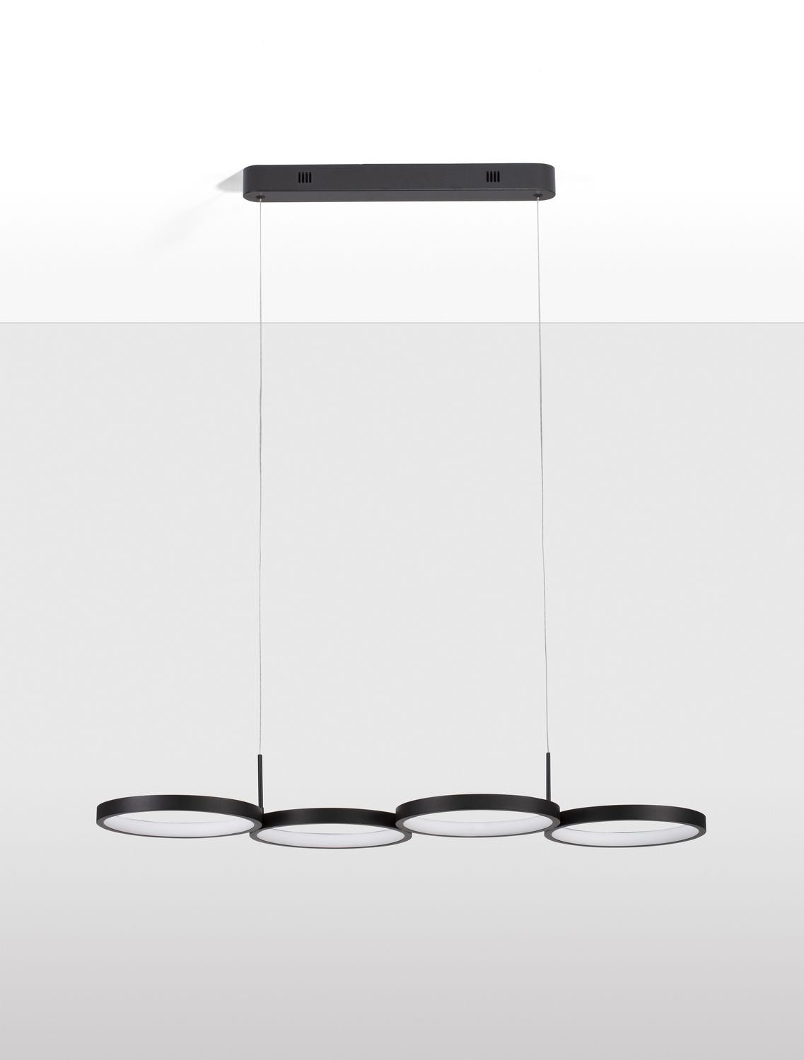 Luminaire suspendu vu de face sur fond gris clair avec ombre portée
