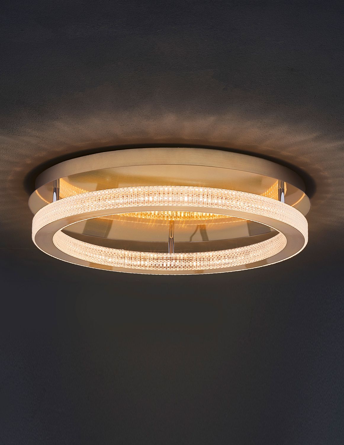 Plafonnier allumé sur plafond sombre, halo lumineux chaud diffusé