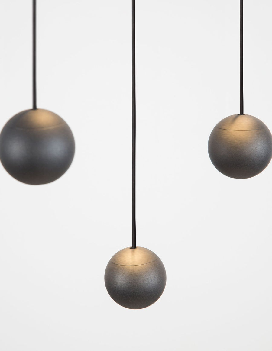 Détail rapproché de trois boules noires au dégradé bronze sur le dessus