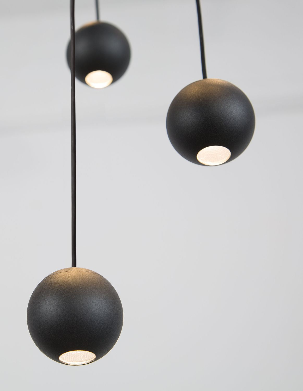 Gros plan sur les diffuseurs allumés sous chaque sphère noire mate