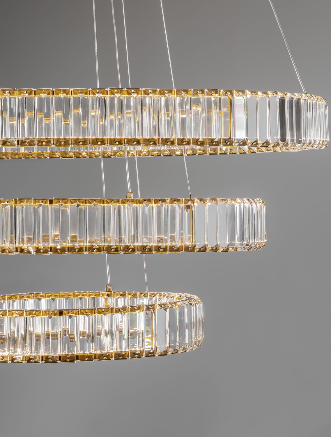 Détail rapproché des anneaux de cristal taillé et de leur armature dorée