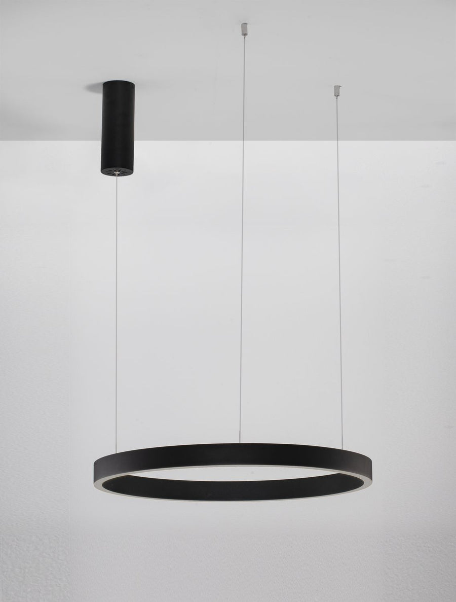 Luminaire installé sous un plafond blanc, anneau noir allumé et câbles fins visibles