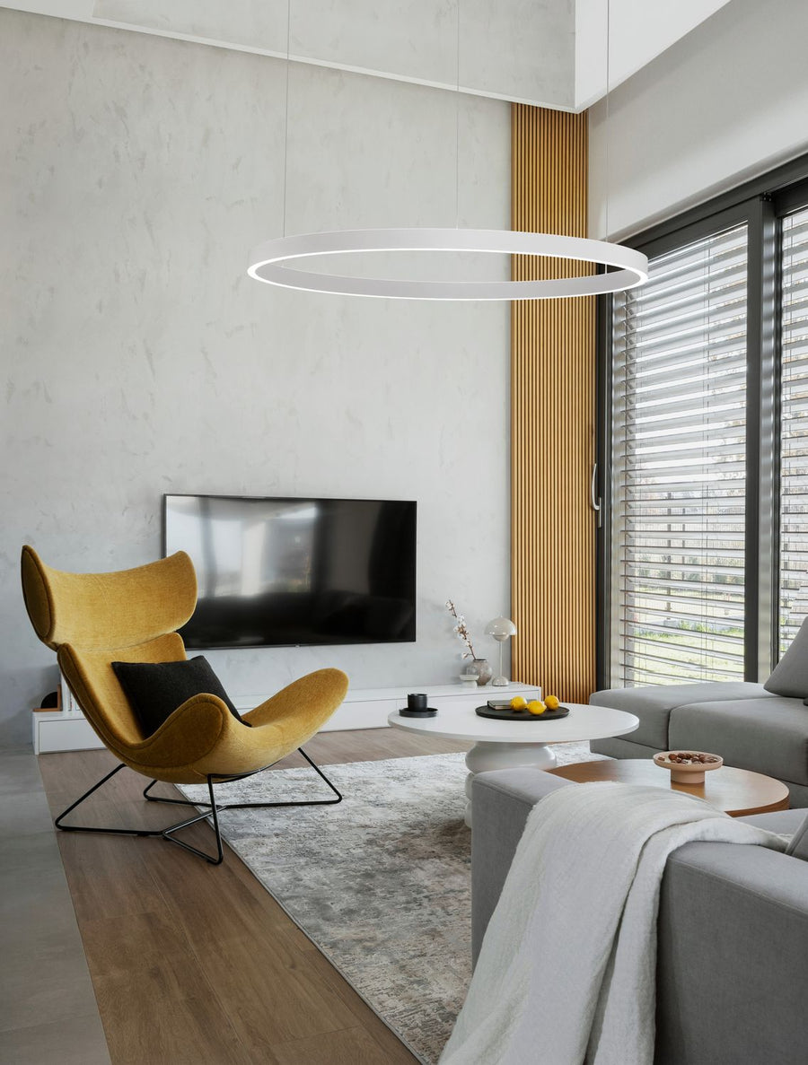 Suspension anneau blanc installée dans un salon contemporain au-dessus d'un fauteuil jaune