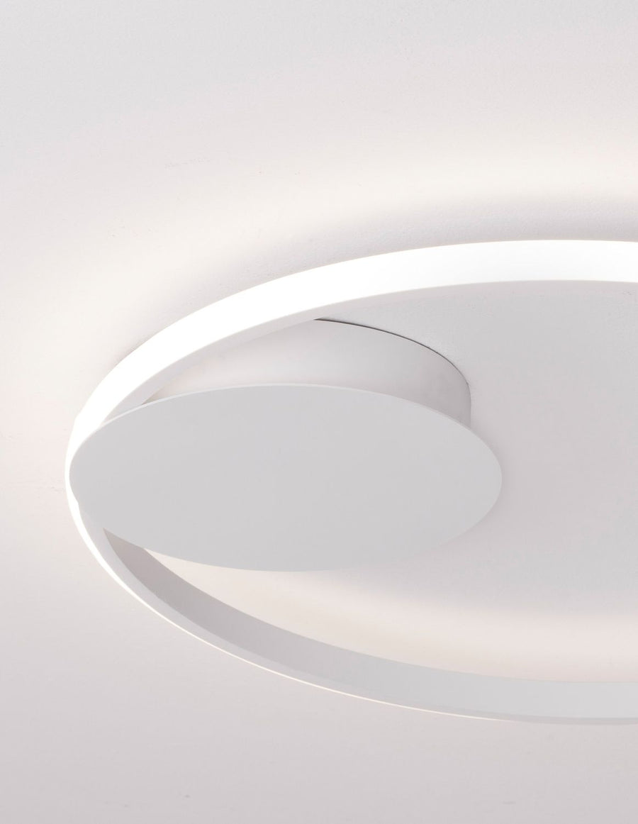 Détail rapproché de l'anneau lumineux et du disque blanc fixé au plafond