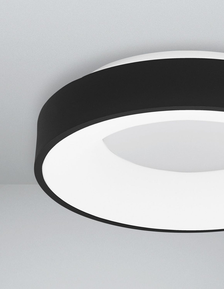 Gros plan sur le bord noir mat et le diffuseur blanc du luminaire