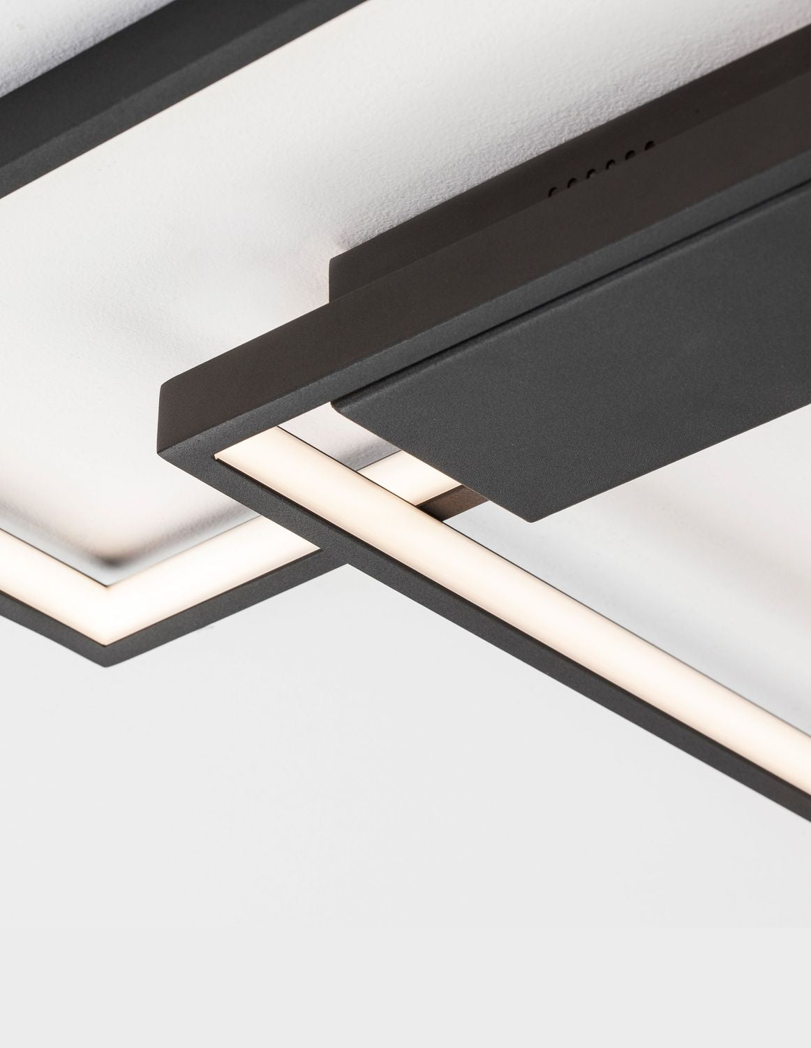 Gros plan sur le ruban LED blanc inséré dans la structure en métal noir