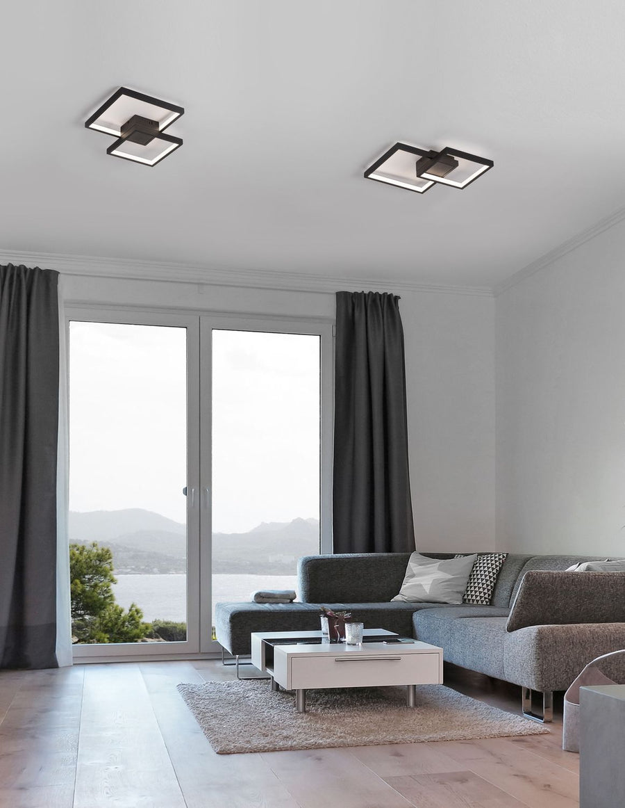Deux plafonniers carrés noirs installés au plafond d'un salon très lumineux