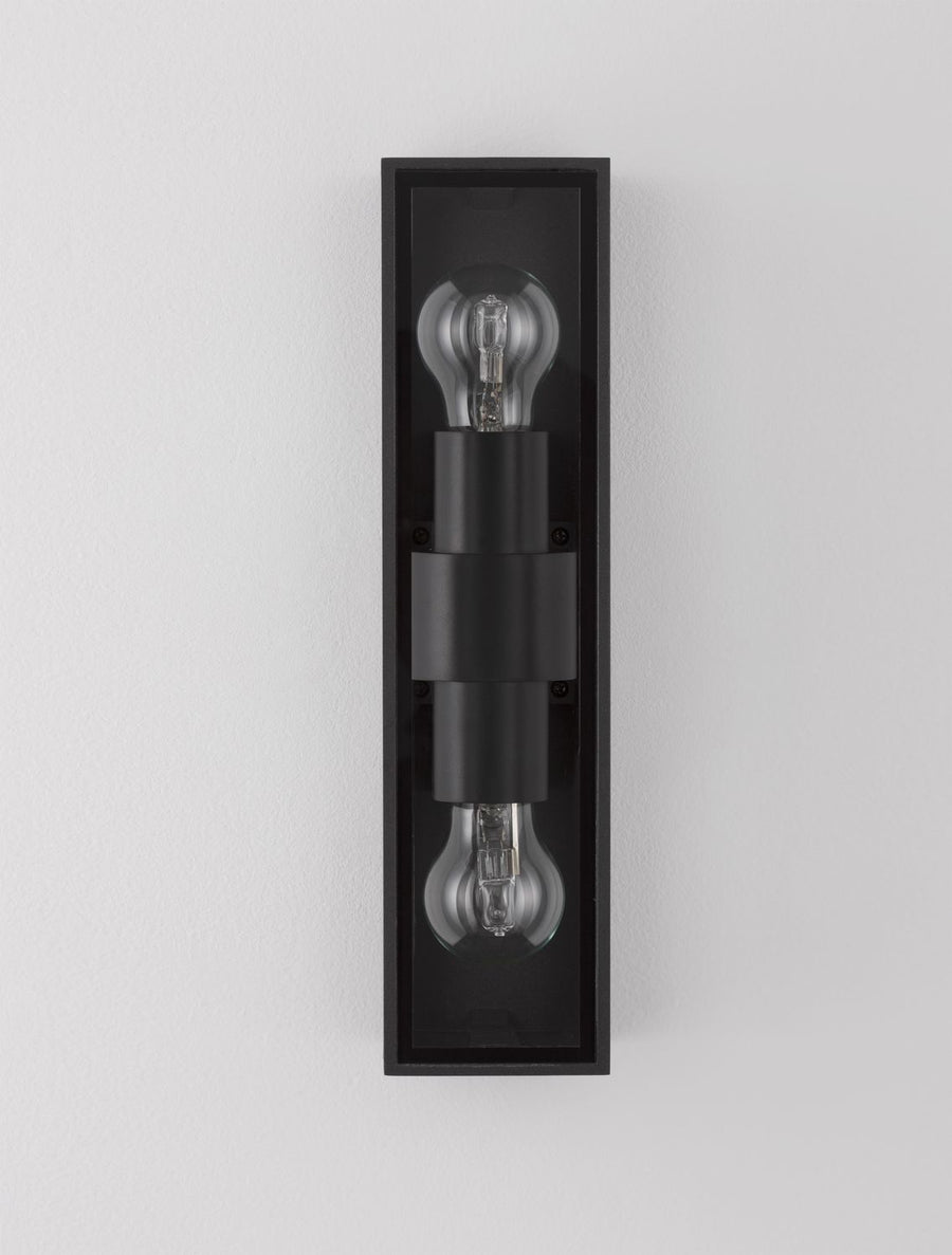 Gros plan frontal sur les deux douilles et ampoules allumées du luminaire