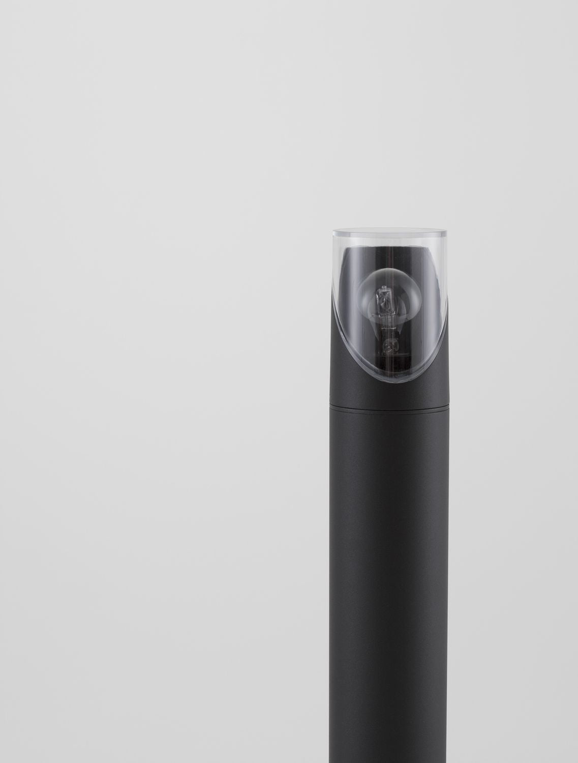 Gros plan sur la tête du luminaire et son ampoule éteinte sous verre