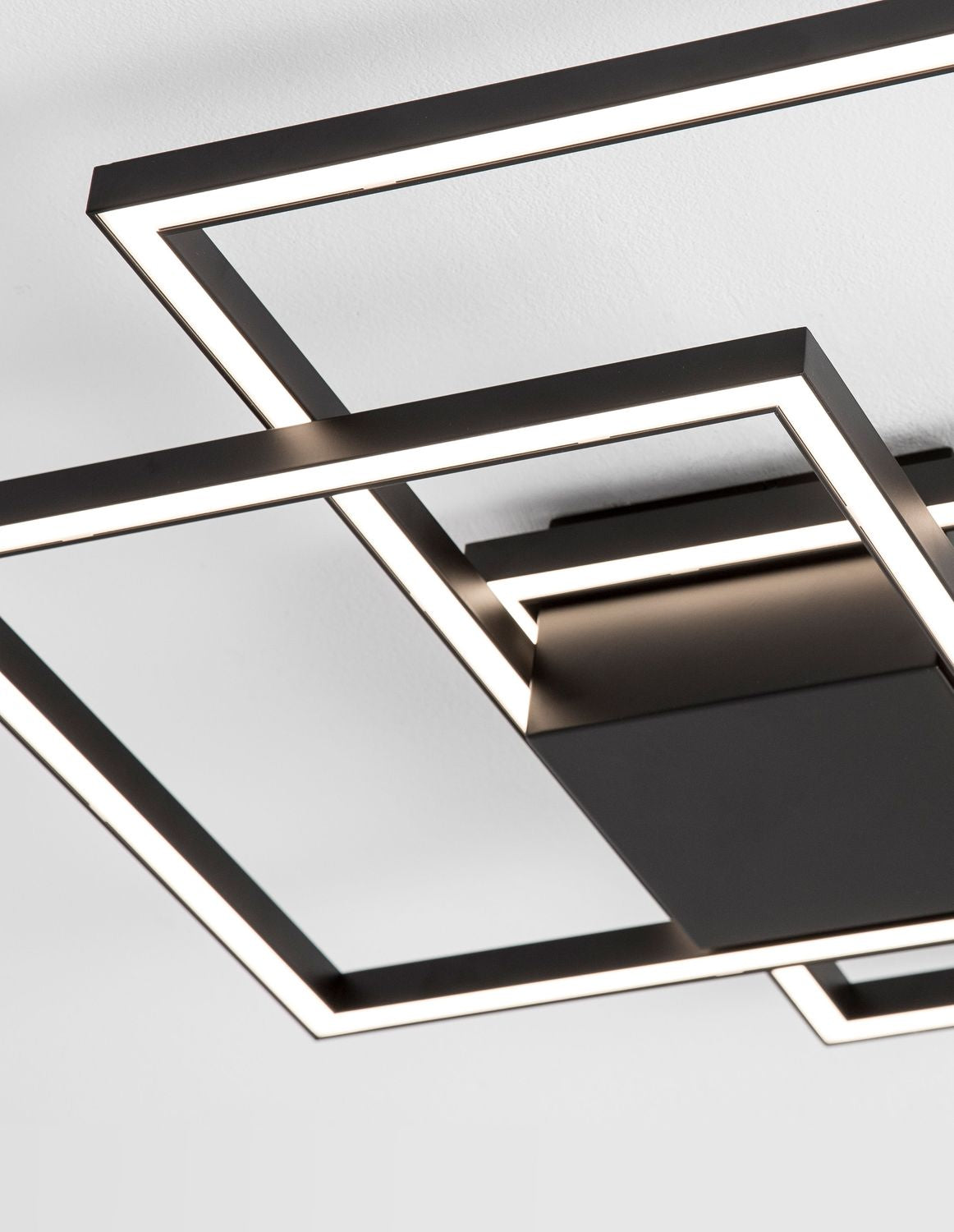 Détail rapproché des rubans LED blancs intégrés aux profilés noirs mats