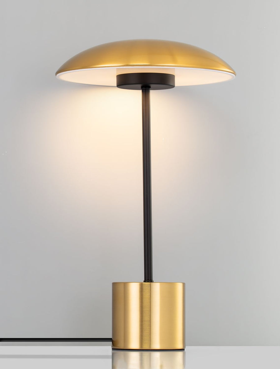 Lampe allumée diffusant une lumière chaude contre un mur gris clair