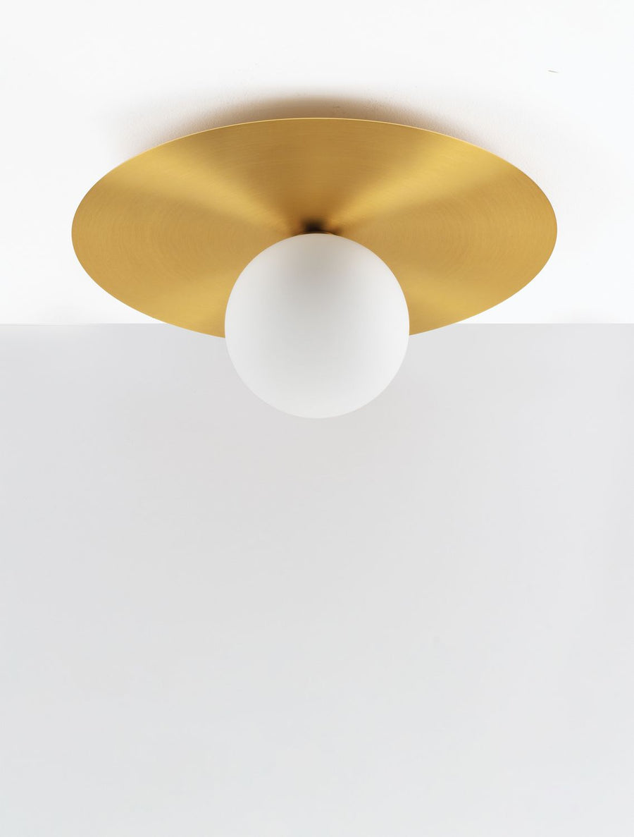 Plan serré sur le reflet doré du disque et la sphère blanche