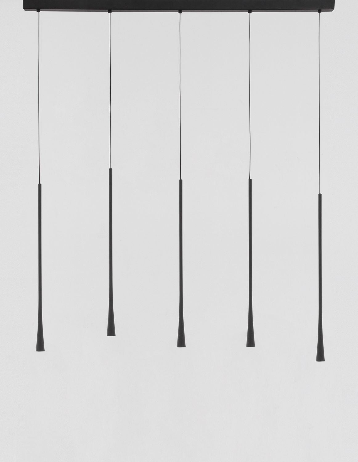 Vue du luminaire entier sur fond clair, cinq longs cônes noirs suspendus à une barre.