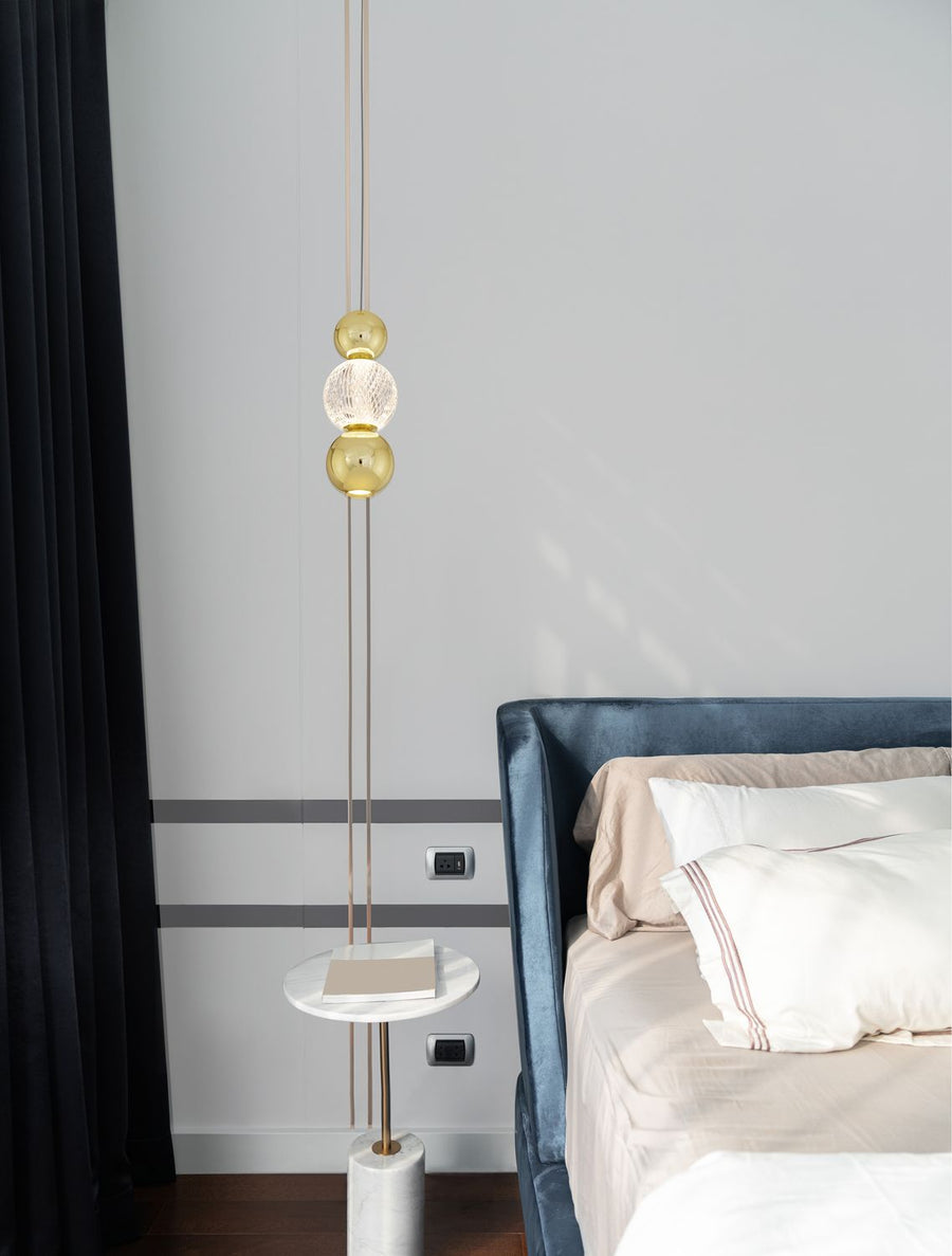 Suspension dorée suspendue au-dessus d'une table d'appoint dans une chambre bleue