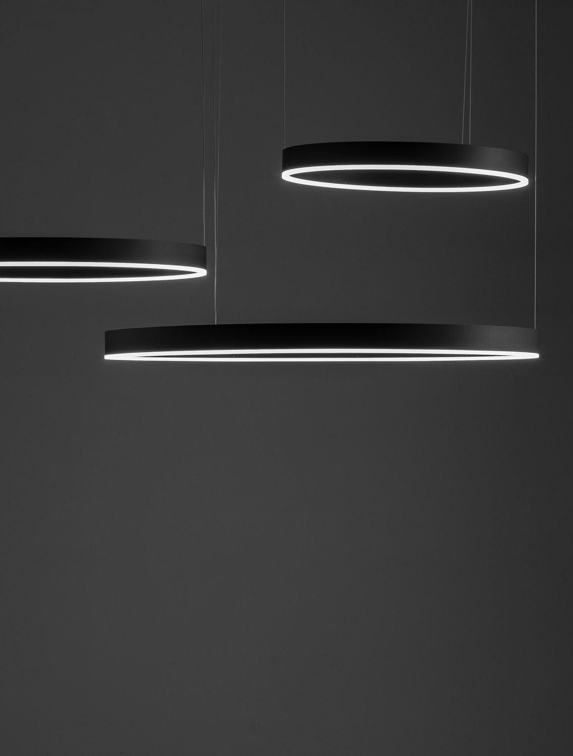 Détail rapproché des anneaux noirs éclairés, lumière blanche sur fond sombre
