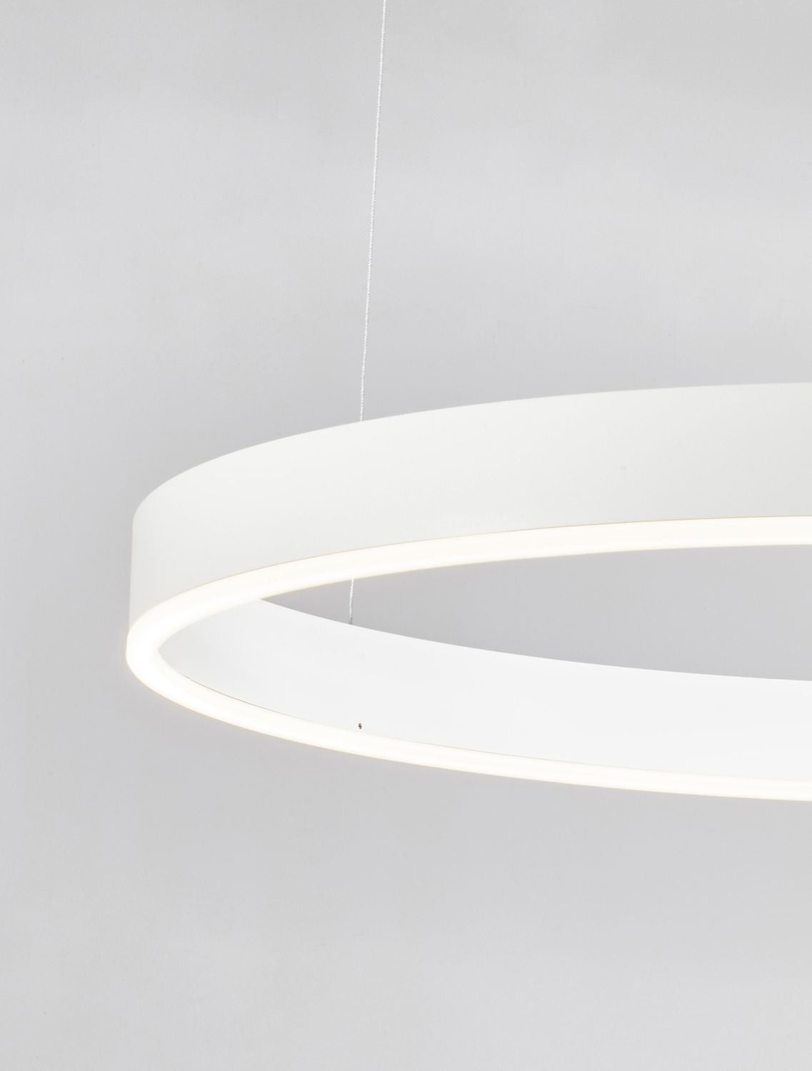 Détail de l'angle de l'anneau blanc avec câble et source lumineuse.