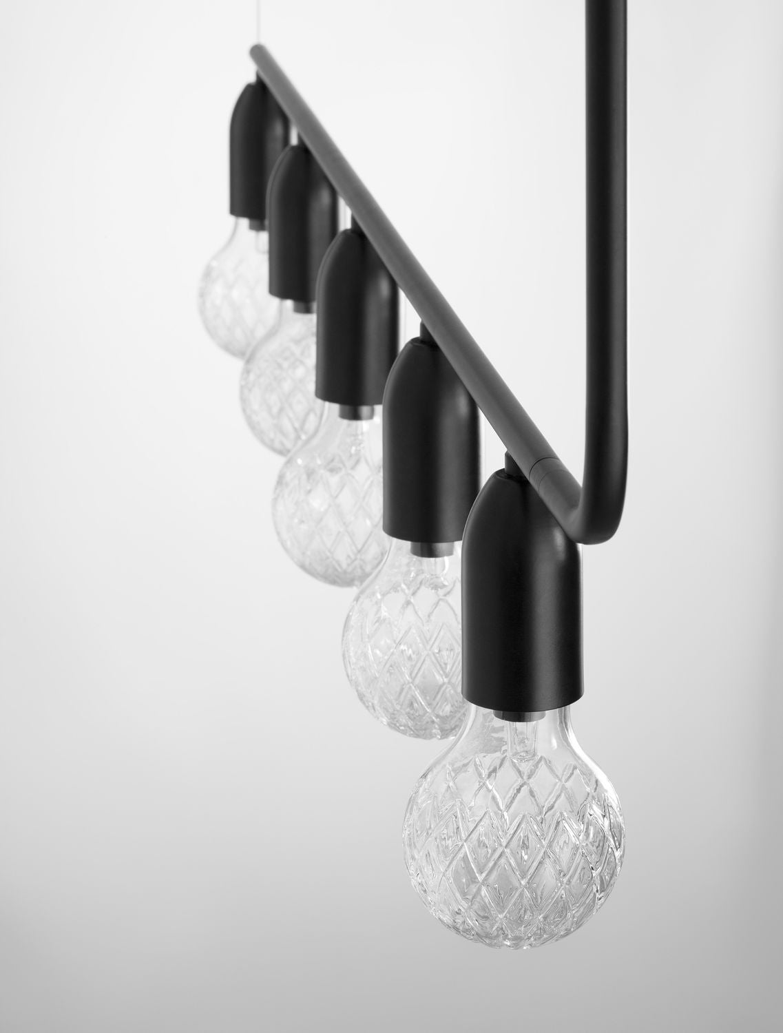 Détail des douilles noires et des ampoules en verre à motif losangé