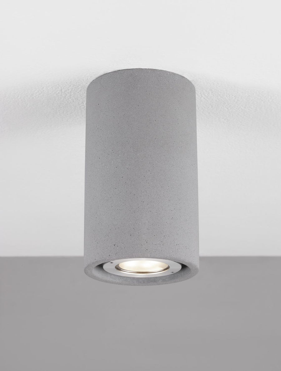 Luminaire installé au plafond, allumé, diffusant une lumière chaude par le verre inférieur.