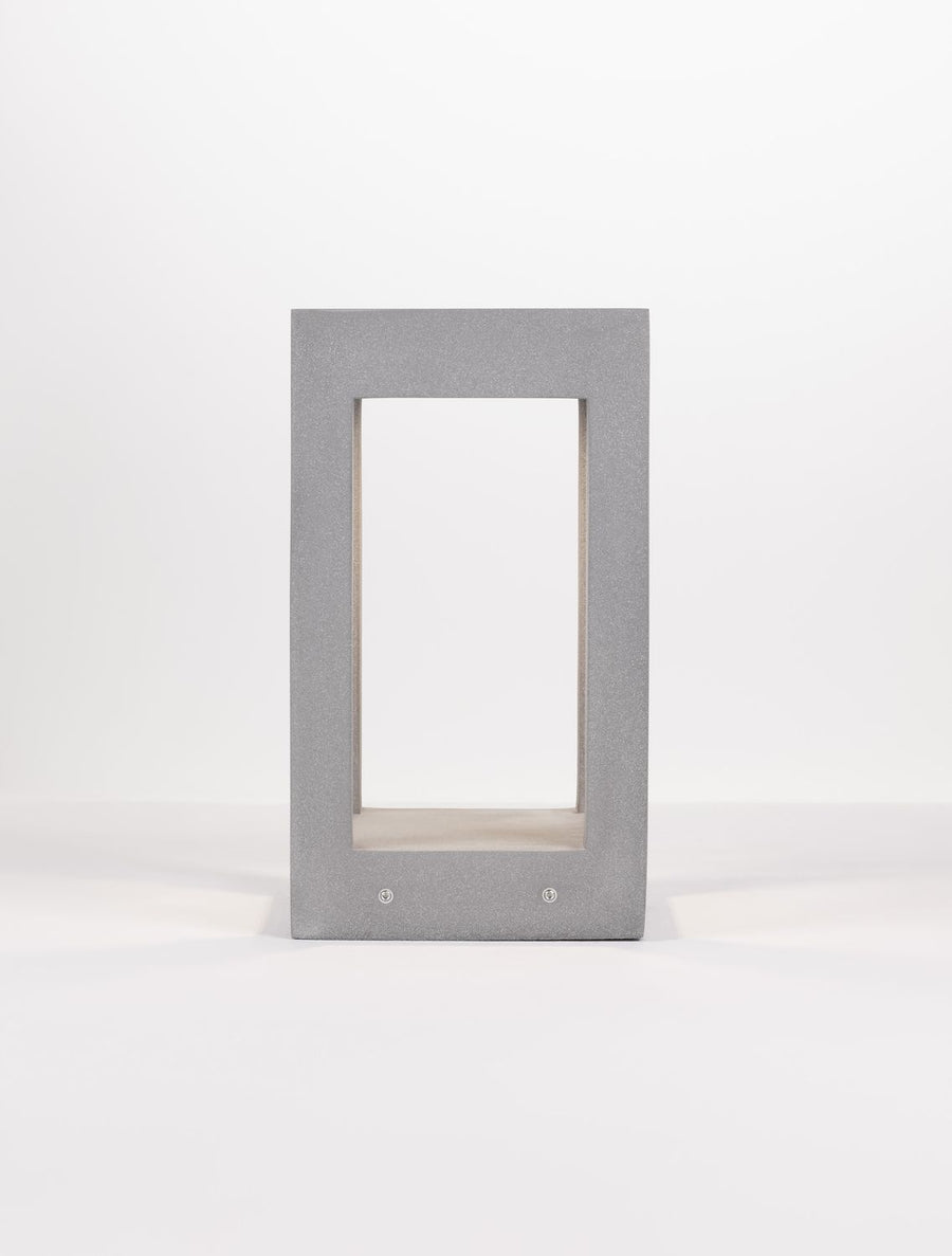 Vue de face rapprochée du caisson gris, montrant le panneau de verre et les vis.