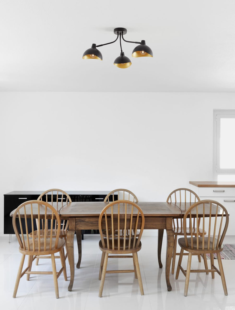 Plafonnier noir suspendu au-dessus d'une table à manger en bois clair