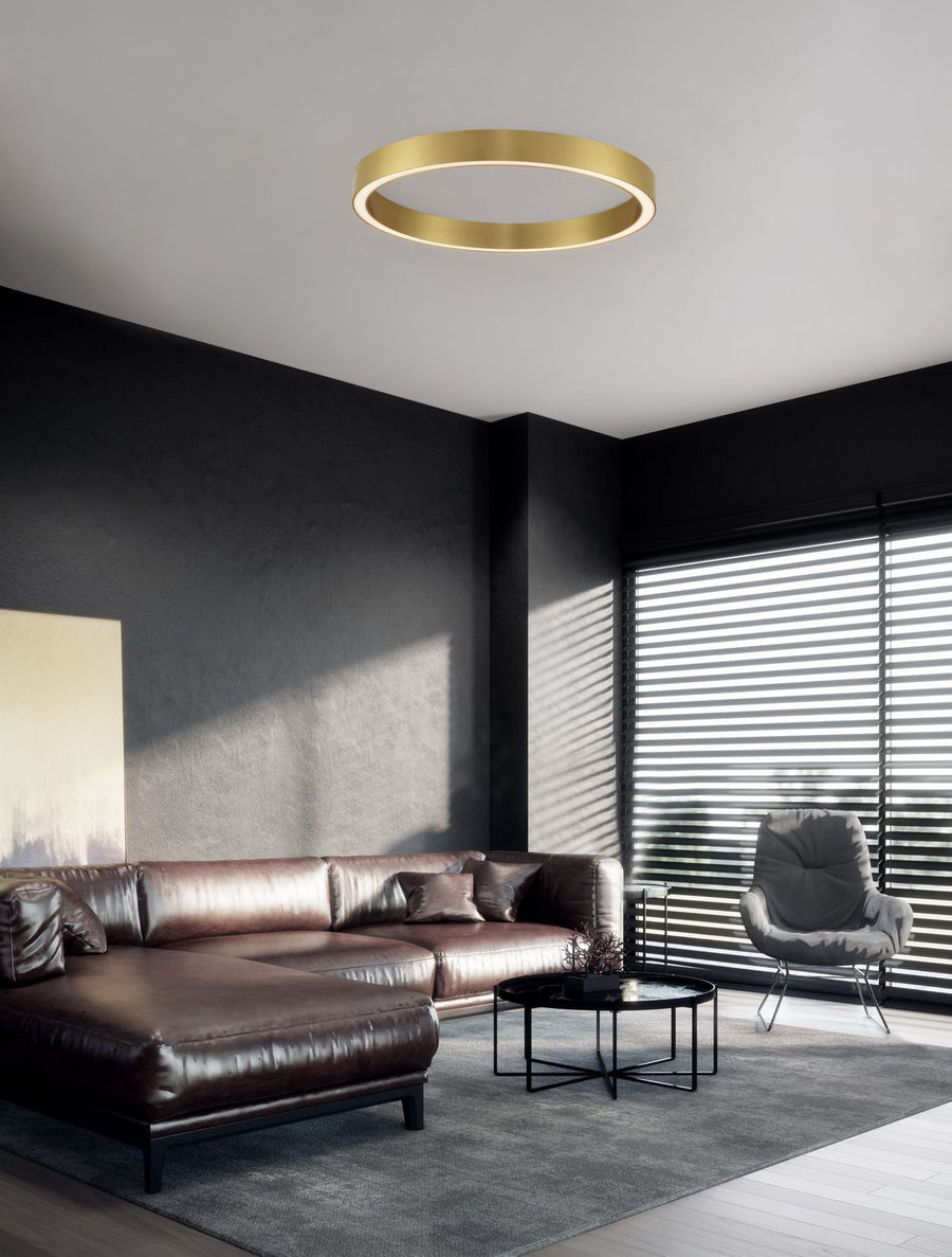 Plafonnier anneau doré installé au plafond dans un salon au décor contemporain