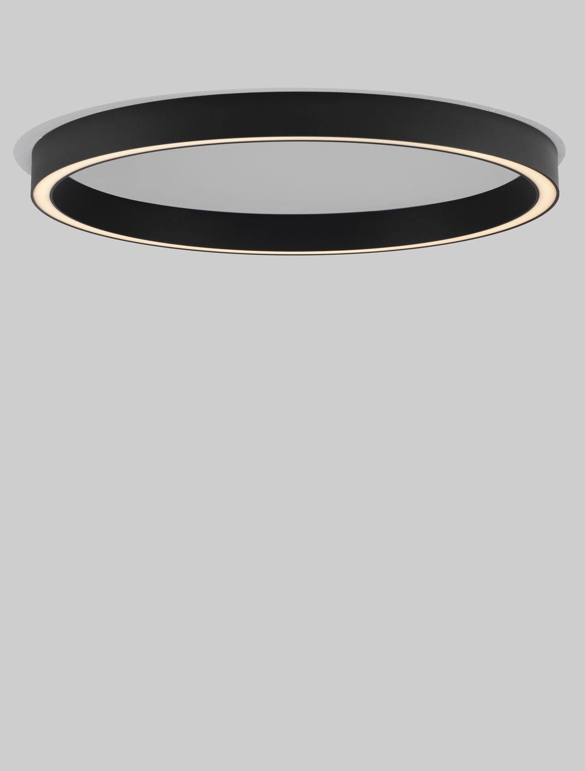Détail du luminaire allumé, anneau noir et lumière chaude.