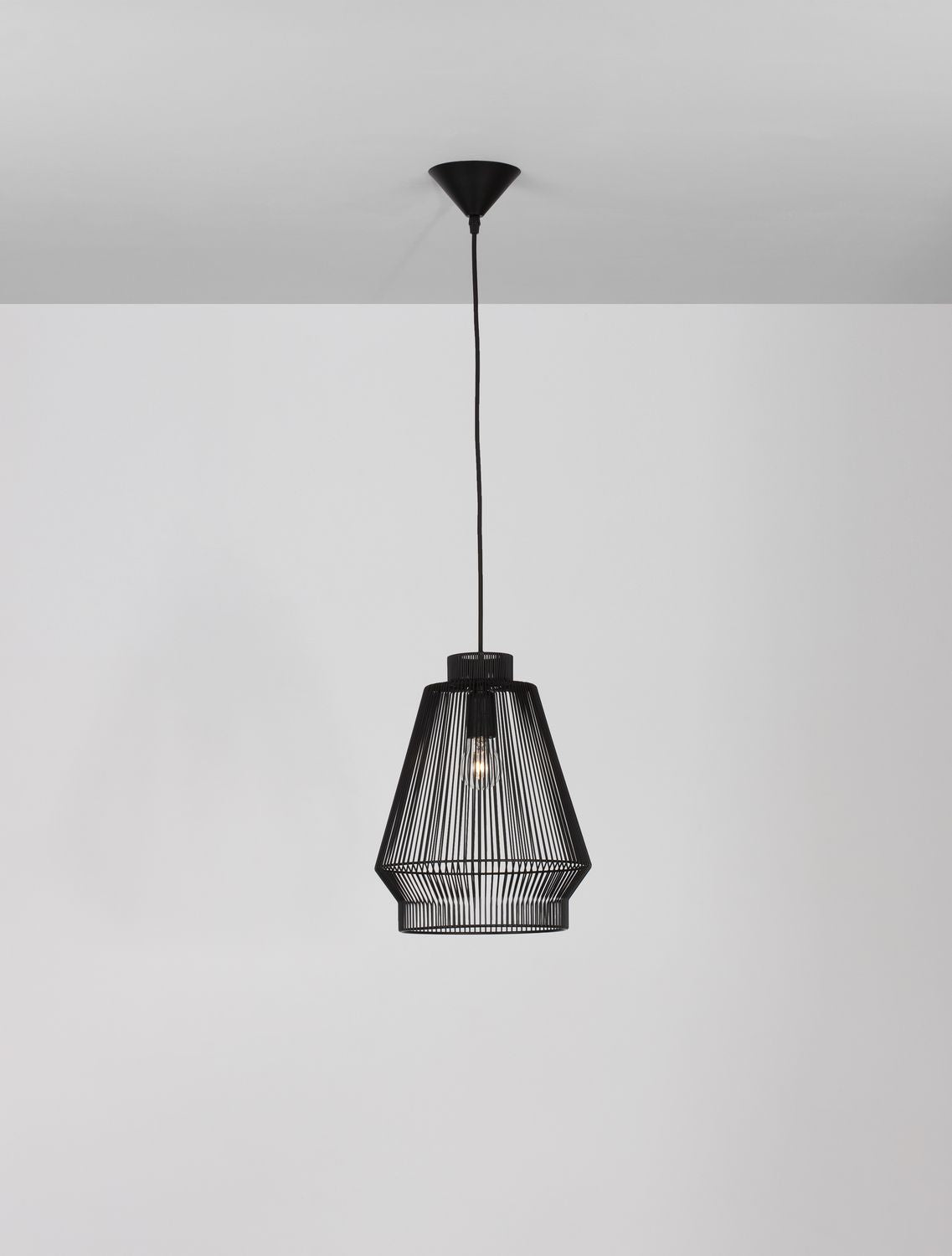 Luminaire suspendu cadré plus large, montrant le câble et la fixation plafond
