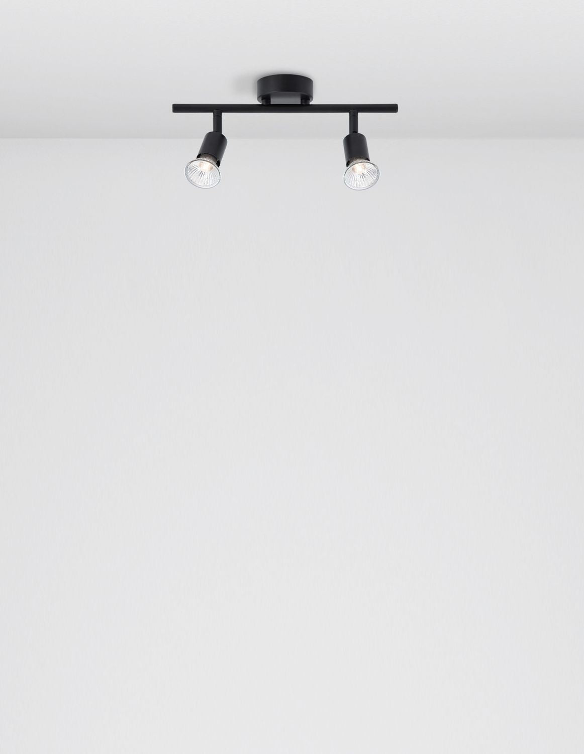 Vue de dessous du plafonnier noir fixé au plafond blanc, spots allumés