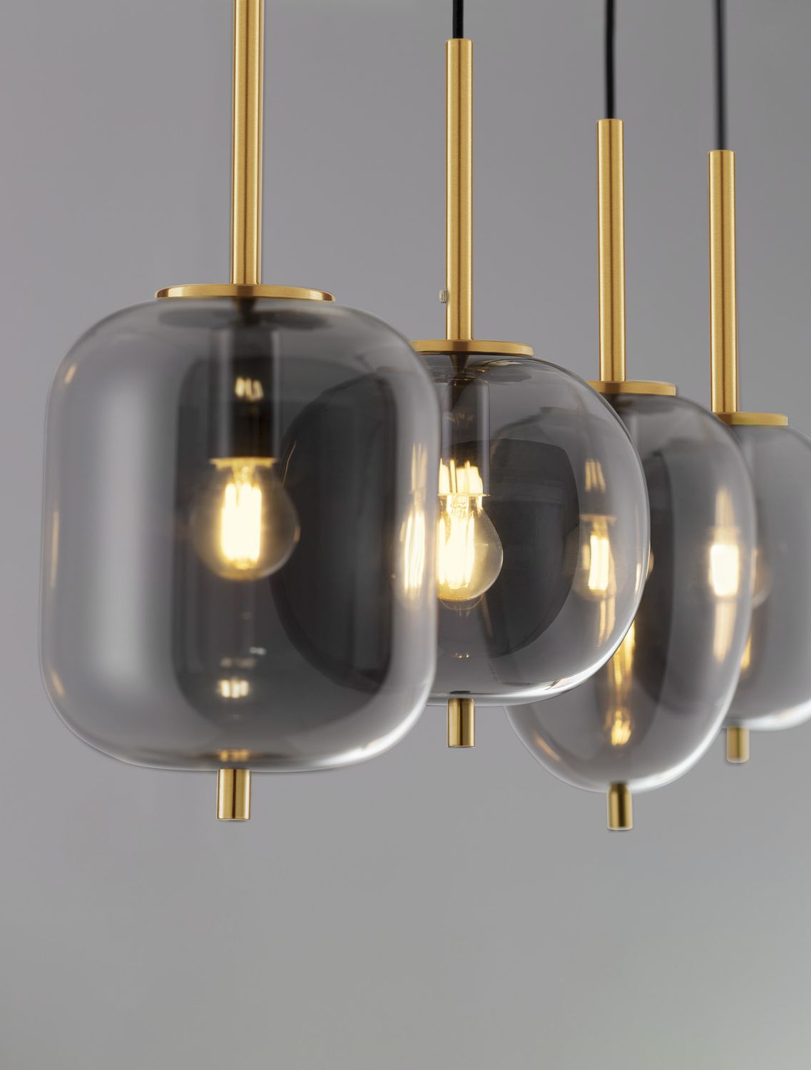 Gros plan sur les globes de verre fumé et les tiges dorées