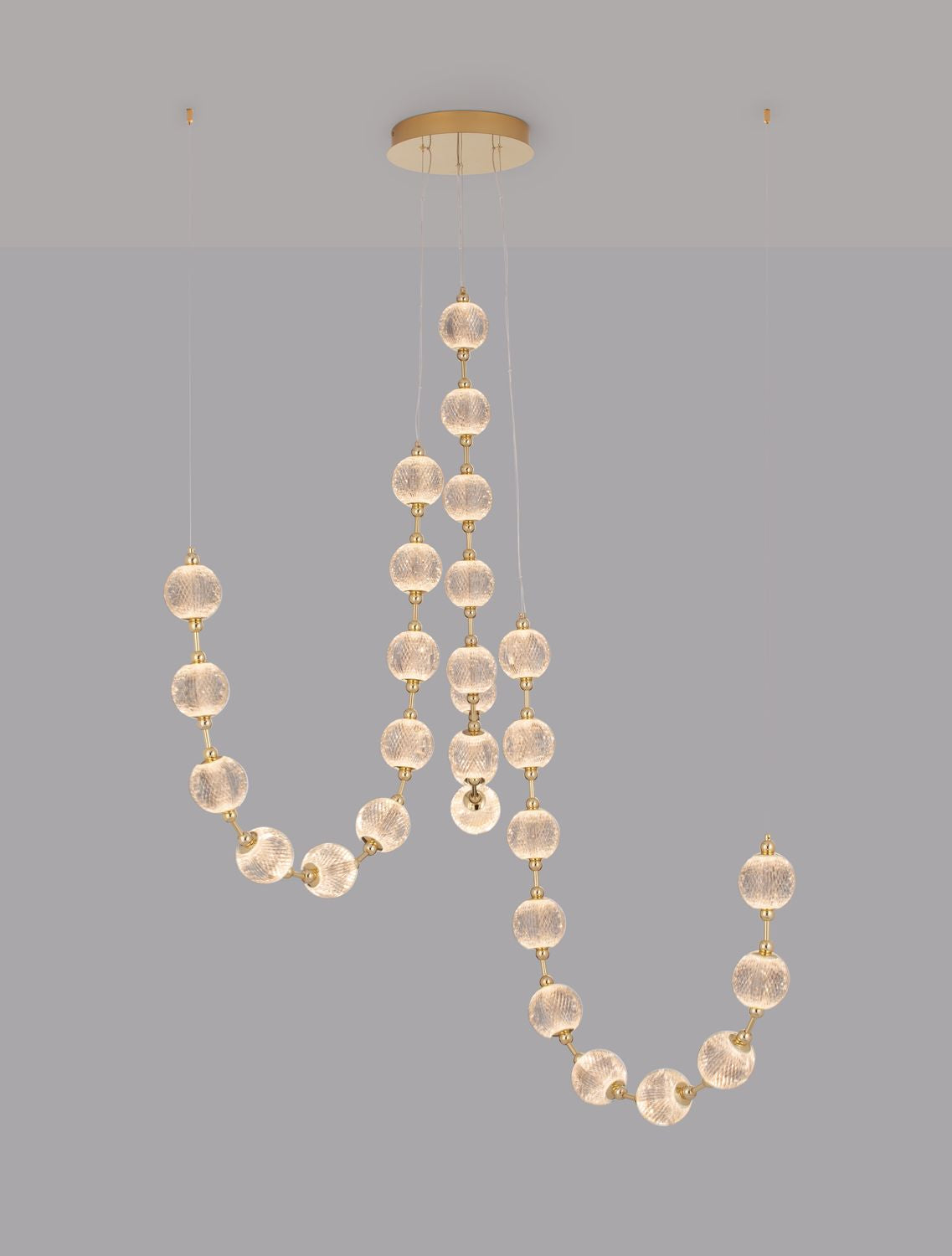 Détail des intercalaires dorés reliant chaque boule de verre texturé